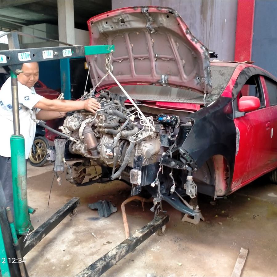 Teknisi mengerjakan mesin mobil di workshop Sukses Mandiri Mobil